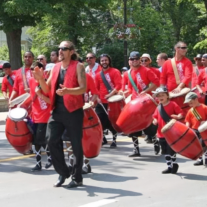 A parade of Candombe drummers in bright red vests